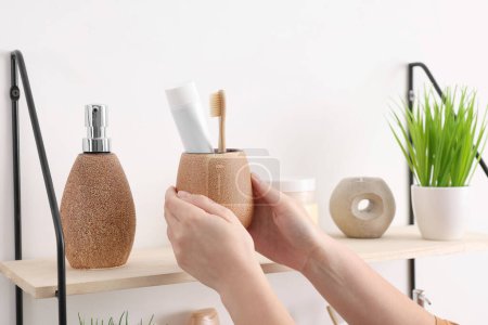 Bath accessories. Woman organizing personal care products indoors, closeup