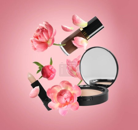 Spring flowers and makeup products in air on coral color background