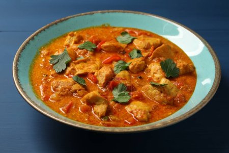 Delicioso pollo al curry en la mesa de madera azul, primer plano