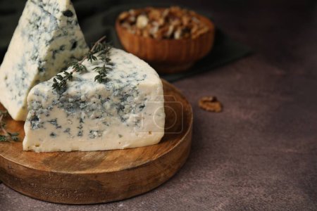 Savoureux fromage bleu au thym sur table brune. Espace pour le texte