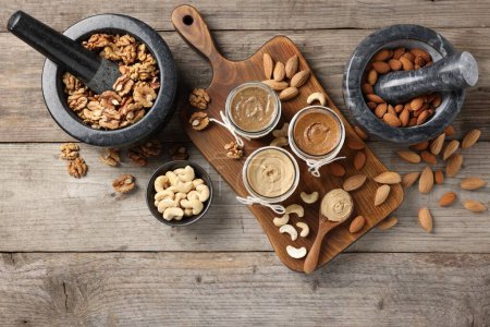 Photo for Making nut butters from different nuts. Fat lay composition on wooden table - Royalty Free Image