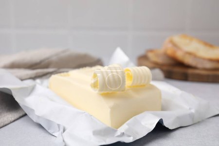 Tasty butter and curls on light grey table, closeup