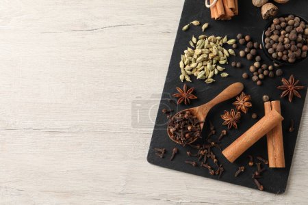 Different spices on wooden table, top view. Space for text