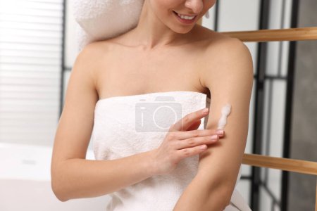 Foto de Mujer aplicando producto auto-bronceado en el brazo en interiores, primer plano - Imagen libre de derechos