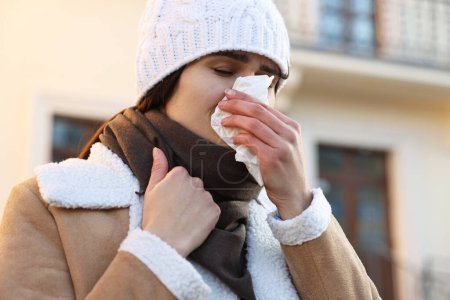 Photo for Woman with tissue blowing runny nose outdoors. Cold symptom - Royalty Free Image
