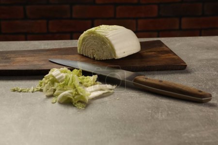 Cut fresh Chinese cabbage and knife on light grey table