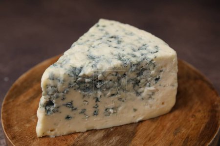 Pièce de savoureux fromage bleu sur planche de bois, gros plan