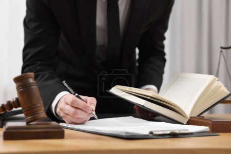 Photo for Lawyer working with documents at table indoors, closeup - Royalty Free Image