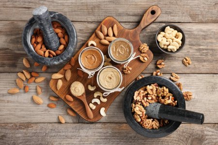 Photo for Making nut butters from different nuts. Fat lay composition on wooden table - Royalty Free Image