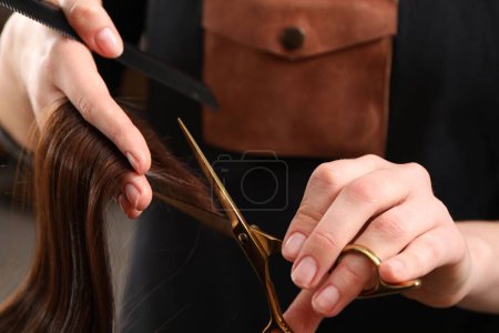 Friseur schneidet Kundin im Salon mit Schere die Haare, Nahaufnahme