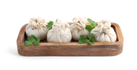 Tray with uncooked khinkali (dumplings) and parsley isolated on white. Georgian cuisine