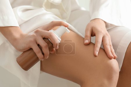 Foto de Mujer aplicando producto auto-bronceado en la pierna, primer plano - Imagen libre de derechos