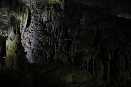 Picturesque view of many stalactite formations in dark cave