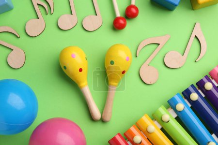 Photo for Tools for creating baby songs. Flat lay composition with maracas on green background - Royalty Free Image