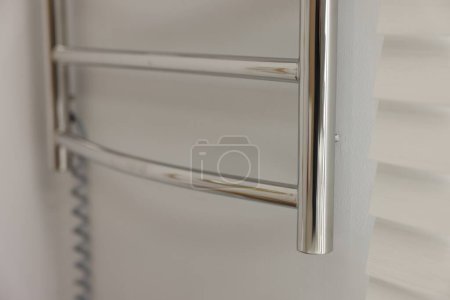 Photo for Heated towel rail on white wall in bathroom, closeup - Royalty Free Image
