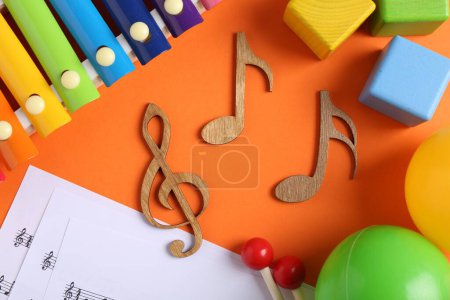 Photo for Creating baby songs. Flat lay composition with wooden notes on orange background - Royalty Free Image