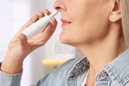 Photo for Medical drops. Woman using nasal spray indoors, closeup - Royalty Free Image