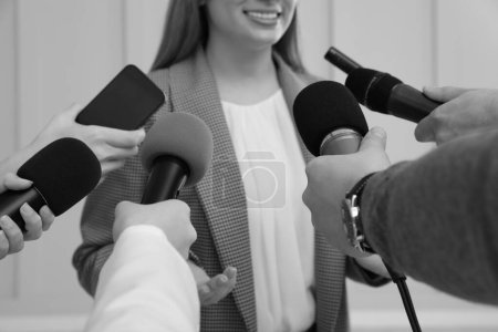 Téléchargez les photos : Femme d'affaires donnant une interview à des journalistes à l'intérieur, gros plan. Effet noir et blanc - en image libre de droit