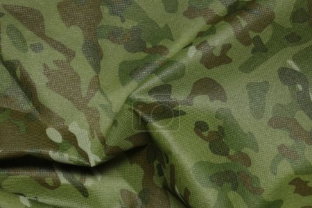 Texture of crumpled camouflage fabric as background, top view