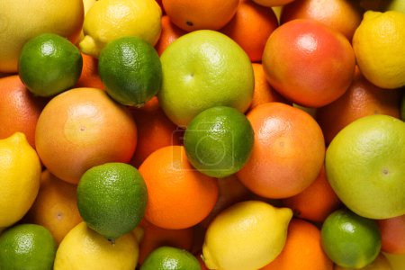 Foto de Different fresh citrus fruits as background, top view - Imagen libre de derechos