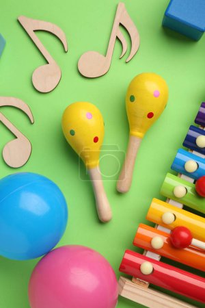 Tools for creating baby songs. Flat lay composition with maracas on green background