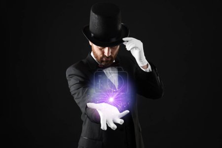 Magic and sorcery. Magician with fantastic light on dark background