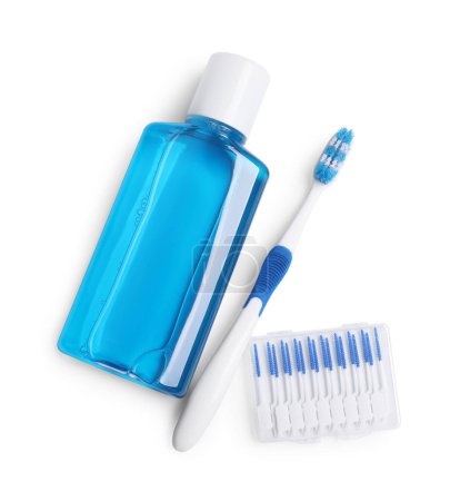 Foto de Enjuague bucal fresco en botella, cepillo de dientes y cepillos interdentales aislados en blanco, vista superior - Imagen libre de derechos