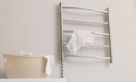 Photo for Heated towel rail with underwear on white wall in bathroom - Royalty Free Image