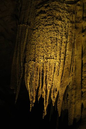 Pintoresca vista de muchas formaciones de estalactitas en cueva oscura