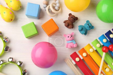 Baby song concept. Wooden tambourines , xylophone and toys on table, flat lay