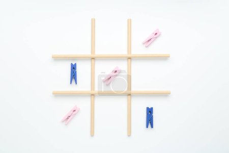 Tic tac toe game made with clothespins on white background, top view