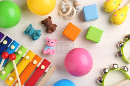 Baby song concept. Wooden tambourines , xylophone and toys on table, flat lay