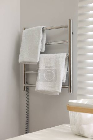 Heated towel rail with towels in bathroom