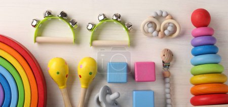 Babygesangskonzept. Flache Lagekomposition mit Spielzeug-Musikinstrumenten auf weißem Holzgrund