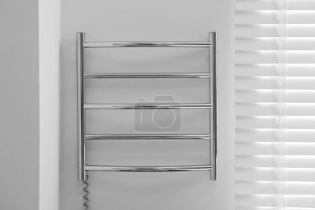 Foto de Toallero calefaccionado en pared blanca en baño - Imagen libre de derechos