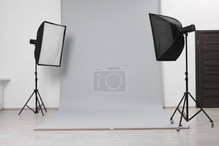 Modern light grey photo background and softboxes in studio