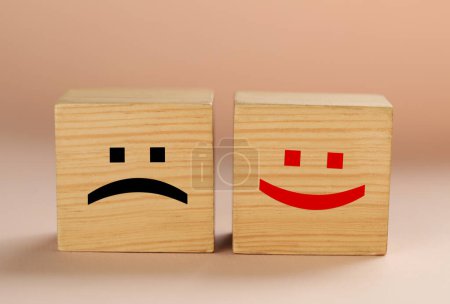 Photo for Wooden cubes with sad and happy faces on beige background - Royalty Free Image