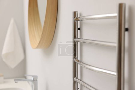 Photo for Heated towel rail on white wall in bathroom, closeup - Royalty Free Image