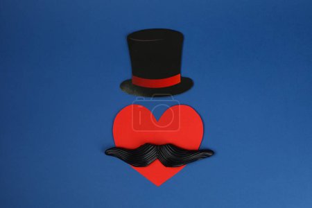 Téléchargez les photos : Fausse moustache, chapeau en papier et coeur sur fond bleu, vue de dessus - en image libre de droit