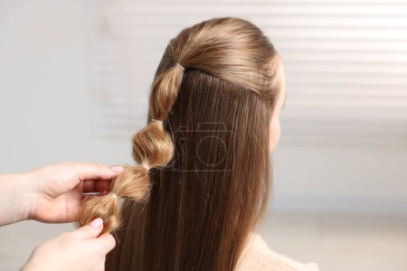 Foto de Estilista profesional trenzando el pelo de la mujer en el interior, primer plano - Imagen libre de derechos