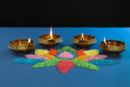 Téléchargez les photos : Fête de Diwali. Lampes Diya et rangoli coloré sur fond bleu - en image libre de droit
