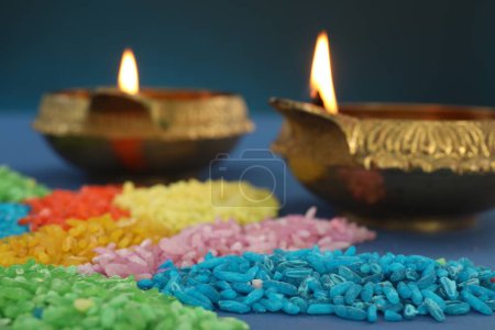 Téléchargez les photos : Fête de Diwali. Lampes Diya et rangoli coloré sur fond bleu, gros plan - en image libre de droit