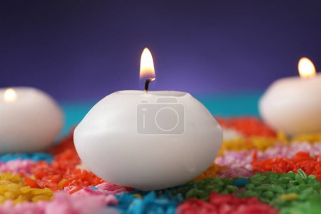 Téléchargez les photos : Fête de Diwali. Bougies brûlantes et rangoli coloré sur fond flou, gros plan - en image libre de droit