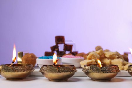 Téléchargez les photos : Joyeux Diwali. Lampes Diya sur table blanche sur fond violet, gros plan - en image libre de droit