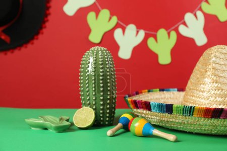 Composition avec chapeau de sombrero mexicain et maracas sur table verte, gros plan