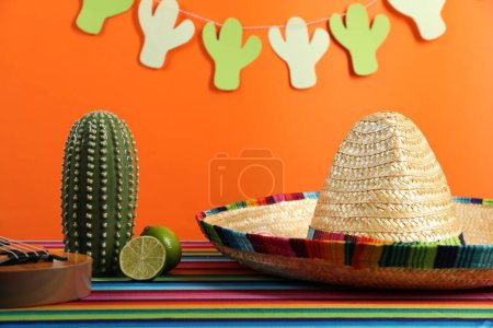 Chapeau sombrero mexicain, cactus décoratif et citron vert sur la table de couleur, gros plan