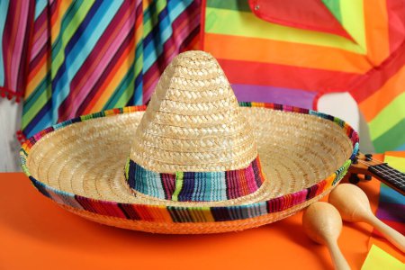 Chapeau sombrero mexicain et maracas sur table orange, gros plan