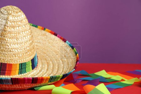 Chapeau de sombrero mexicain sur table rouge, gros plan. Espace pour le texte