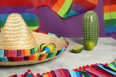 Composition avec chapeau de sombrero mexicain et maracas sur table texturée grise