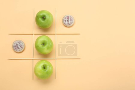 Tic Tac Toe Spiel mit Äpfeln und Keksen auf beigem Hintergrund, Draufsicht